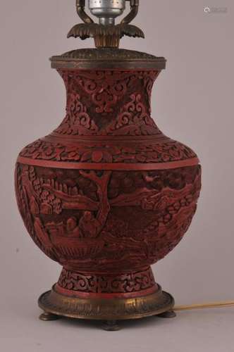 Cinnabar vase. China. Circa 1900. Surface carved with figures in a landscape. Drilled and mounted as lamp.  Cinnebar- 8-1/2