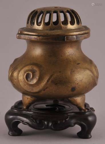 19th century Chinese Bronze three footed covered censer with raised scroll decoration. Carved wood fitted base. 4-1/2