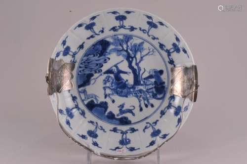 Chinese Kang Xi Dynasty blue and white decorated porcelain silver mounted handled dish. Hunting scene with floral panels. Continental silver hallmarks inside handle. Hallmarked on vase. Two-minute flake chips on underside top rim with tight hairline cracks. One other tight hairline crack from top rim. 8