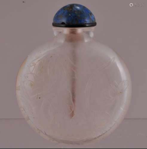 Rock crystal snuff bottle. China. 19th century. Flattened round form. Surface carved with flowers and birds. Well hollowed. Fissure in the body.  3