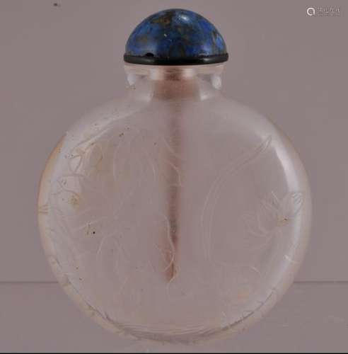 Rock crystal snuff bottle. China. 19th century. Flattened round form. Surface carved with flowers and birds. Well hollowed. Fissure in the body.  3