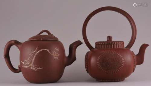 Two Chinese Yixing pottery teapots. (1) Chrysanthemum decorated pot with large handle. Signed inside cover. 7-1/2