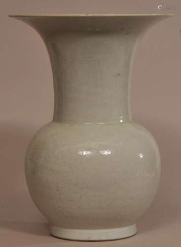 White porcelain vase. China. 19th century. Globular body with a widely flaring mouth. Surface engraved with ju-I, acanthus leaves and floral scrolling. Hairline crack and chip to the mouth. 13