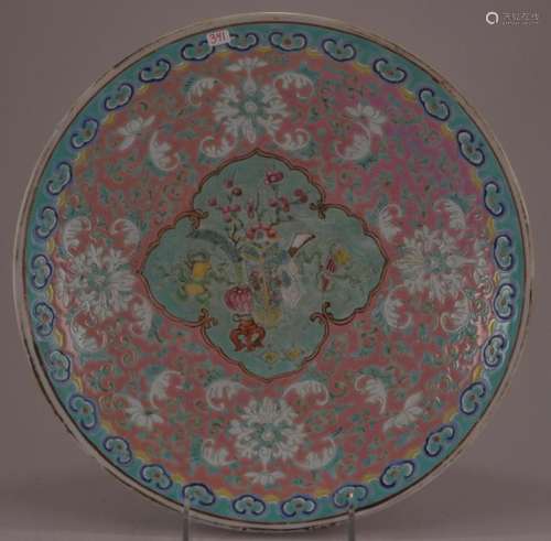 Porcelain plate. China. 19th century. Decoration of ju-I, lotus scrolls on a mauve ground around a central reserve of The Hundred Antiques.   11-1/2