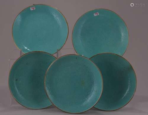 Lot of five saucer dishes. China. Late 19th to early 20th century. Engraved decoration of dragons and pearls around a central Shou medallion beneath a turquoise glaze. Four-character hallmark on the base.  5-3/4