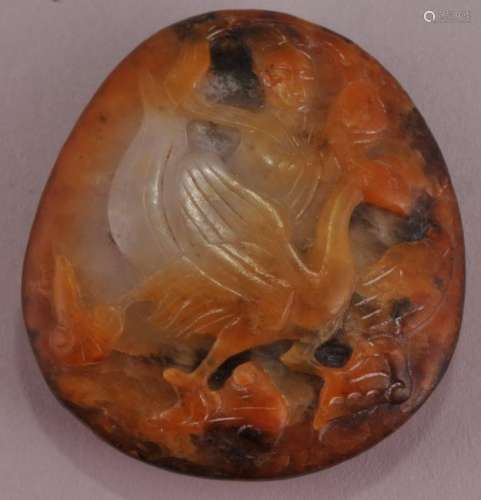 Jade pebble. China. 19th century. White stone with amber skin. Surface carved with a phoenix.  1-1/2