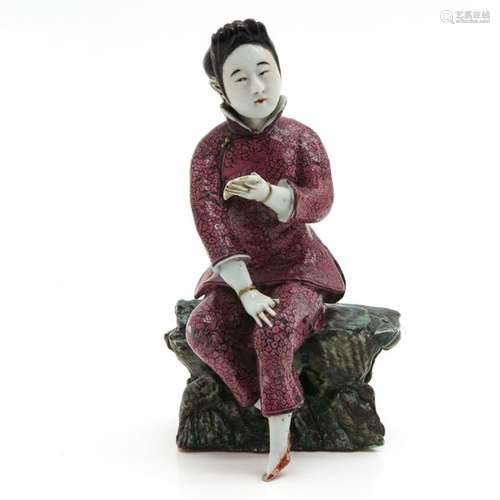 A Porcelain Sculpture of Seated Woman Dressed in p...