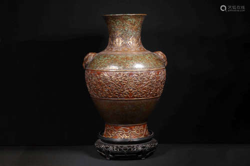 GILT BROWN GLAZED AND CARVED 'FLOWERS' LARGE VASE WITH BEAST MASK HANDLES AND WOODEN STAND