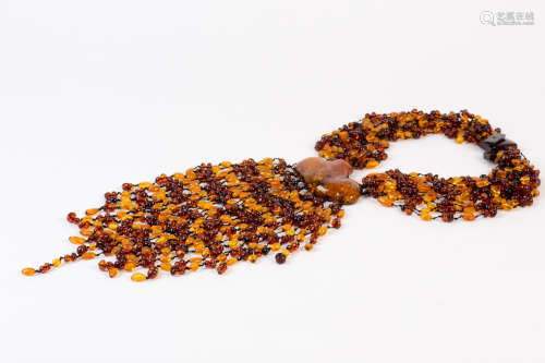 Unique 12 strand amber necklace with large center 3 1/4 in W piece of amber and 14 beaded strands cascading down from it. Total length is around 25 in.
