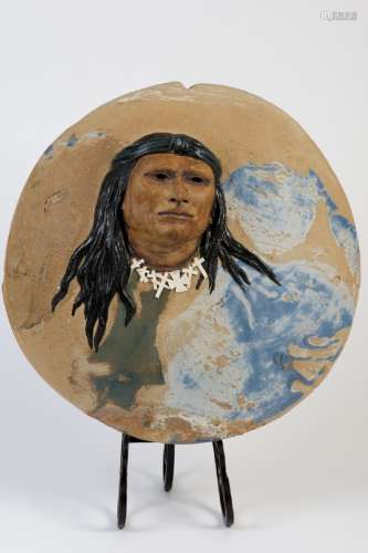 Ceramic circular 15 in diameter hand made slab vessel with exquisite 3-D portrait of a Native American with long black hair. He is wearing a white necklace which contrasts to the earth tones of the ceramic piece. There are blue abstract colors on the front and the back. It is signed Tom Torleno Navajo. Tom Torleno was a member of the Navajo Nation, and this piece is a portrait of him. This piece may have been made by a Virginia woman potter in the 1960's or 1970's.