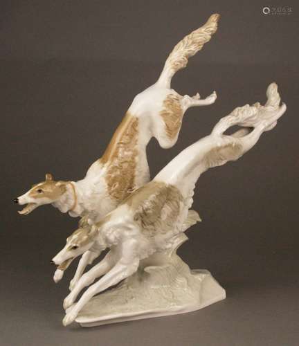 Art Déco figure ''Russian greyhounds'' - Hutschenreuther, art department Selb, bottom signed<br />''K.Tutter'', Nr. 2, fully plastic representation of a Borsoi couple in graceful jump movement, naturalistic underglaze painting, on naturalistic rock base, designed by Karl Tutter in 1933, one ear bumped, HxL.ca.30x35cm