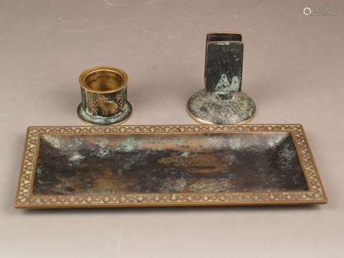 Raucherset - Bronze, grün und braun patiniert, 3-tlg.: 1 rechteckiges Tablett, Rand mit<br />ornamentalem Reliefdekor, ca.27x11,5cm, 1x kleiner Aschenbecher, umlaufend Reliefdekor mit Elefant bzw. Kamel, H.ca.4cm, 1x Streichholzhalter auf rundem Fuß, H.ca.9cm, Alters- bzw. Gebrauchsspuren