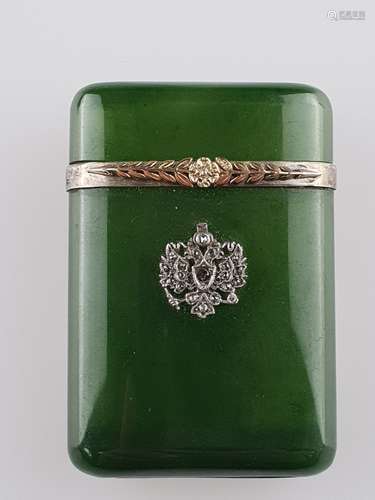 Small stone cut box of green jade in the style of Fabergé - Russia, rounded high<br />rectangular shape with plug-in lid, silver mount (stamped ''Kokoshnik-mark with head to the right 88 [Zolotniki]'' and master  mark ''HN'', on both sides applied flower garland (stamped ''56 St.Petersburg'' (56 Zolotniki = 14ct. gold), obverse side with crowned double-headed eagle, set with differently sized diamond roses and a ruby, stones with slight signs of age, cover inside lateral with small eruption, ca.5,7x4,9cm, weight ca.42,2g , in original case