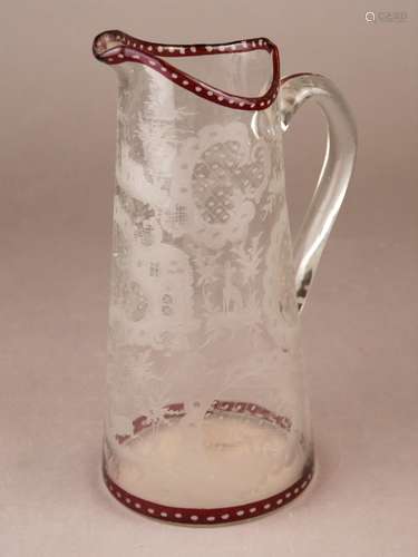 Glaskrug - 19.Jh., farbloses Glas, Ätzdekor mit Burgmotiv sowie Wildtieren und<br />Rocallendekor, Ränder sowie Henkel partiell rot bemalt, geschliffener Bodenabriss, Alters- bzw. Gebrauchsspuren, H.ca.27cm