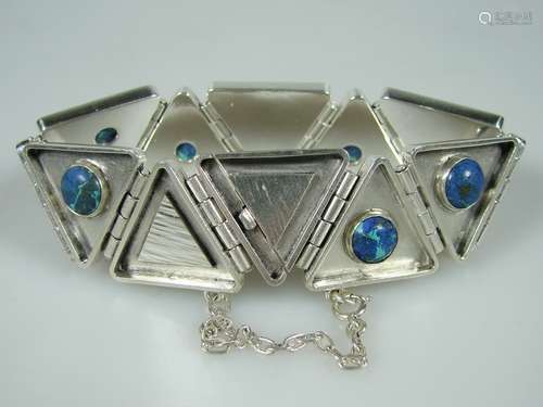 Designerarmband mit Azurit- 1970er Jahre, 925er Silber, 12 dreieckige, partiell satinierte<br />Glieder, durch Scharniere beweglich miteinander verbunden, mit 7 Steincabochons besetzt, Kastenschloss mit Sicherheitskette, Länge: ca.20 cm, Breite:ca. 22 mm, Gewicht: ca.56,8 g, gepunzt: Meisterpunze RH / 925