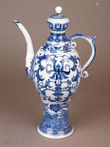 Jug - China, slim ovoid shape on a high base, porcelain, painted in underglaze blue with<br />flowers and leaf motifs, curly spout glued, lid probably added later, H.ca.31cm