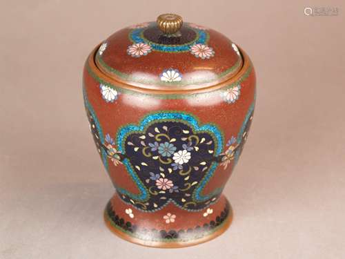 Cloisonné lidded vessel - Japan, Meiji / Taisho period, cloisonné enamel, chrysanthemum<br />motifs on brown background with fine golden tendril pattern, partly in curly cartouches, encircling decorative borders, round lid with fully plastic chrysanthemum knob, traces of age or wear, H.ca. 15.5 cm