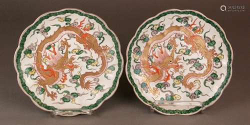 Pair of dragon plates - China, porcelain with enamel decoration and gold, in the well<br />five-clawed dragon among Lingzhi clouds, surrounded by clouds border and gold rim, on the outer wall red line border, bottom with a blue six-charakter mark of the Emperor Qianlong, later modern version, slight abrasion, 1x chipped on the underside of the edge, dia.ca.23 cm