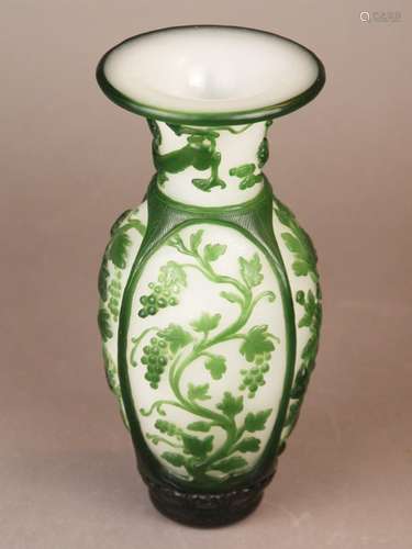 Glass Vase - Beijing Glass, China,<br />baluster shape with flared lip, green overlay on opaque white glass with engraved scales / wave pattern: in oval cartouches grapevine and gourd tendrils, on the neck chilongs with pearl and Lingzhi clouds, H.ca.25cm