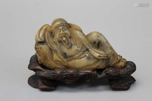 Chinese soapstone figurine on a wood stand.