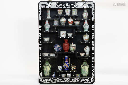 small oriental displaycabinet with Chinese cosmetic’s jars, vases, …