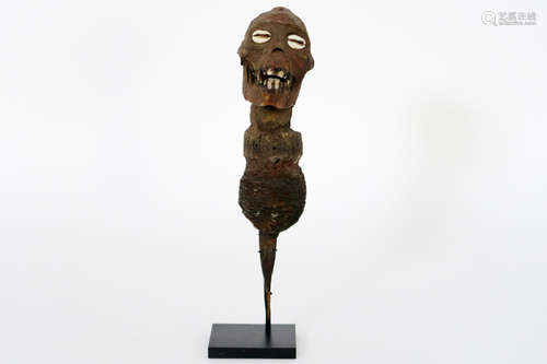 African” fetish sculpture form the “Fon” in wood, metal, textile with a ape’s skull and caurishells