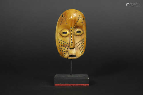 African Congolese ‘Lega’ sharm in the shape of a mask in ivory with the typical Lega characteristics