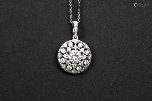 round pendant in white gold (18 carat) with a central 0,71 carat high quality brilliant cut diamond and ca 1,30 carat of small high quality brilliant cut diamonds – with a chain in white gold (18 carat)