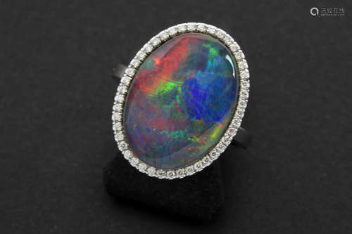 ring in white gold (18 carat) with an oval high quality black opal (with a lot of red spots !) and ca 0,20 carat of very high quality brilliant cut diamonds