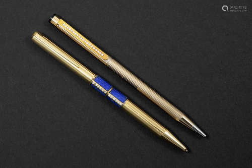 two ballpoint pens each with a gold grip with precious stones