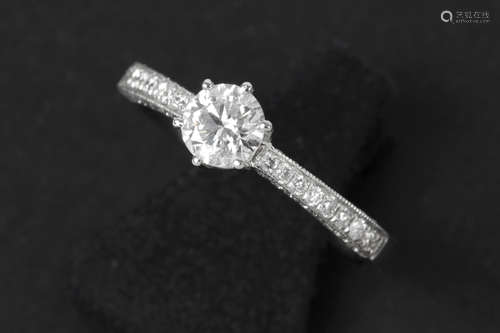 a 0,51 carat high quality brilliant cut diamond set in a ring in white gold (18 carat) with at least 0,30 carat of small high quality brilliant cut diamonds