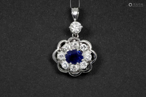 flowershaped pendant in white gold (18 carat) with a 0,85 carat sapphire from Ceylan and ca 1,10 carat of very high quality brilliant cut diamonds