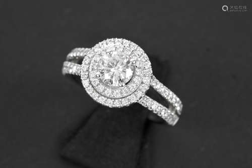 a 0,56 carat high quality brilliant cut diamond set in fashionable ring in white gold (18 carat) with at least 0,40 carat of high quality brilliant cut diamonds