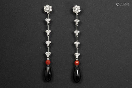 pair of early twenties’ style earrings in white gold (18 carat) with red coral, black onyx and at least 0,40 carat of brilliant cut diamonds