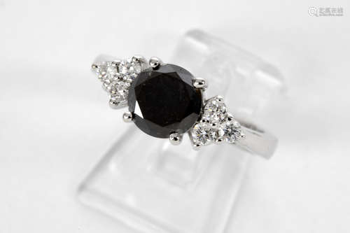 a black high quality brilliant cut diamond of 1,77 carat set in a ring in white gold (18 carat) with ca 0,30 carat of white very high quality brilliant cut diamonds