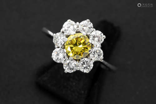 ring in white gold (18 carat) with a 0,71 carat treated fancy vivid yellow high quality brilliant cut diamond , surrounded by ca 1 carat of small white high quality brilliant cut diamonds