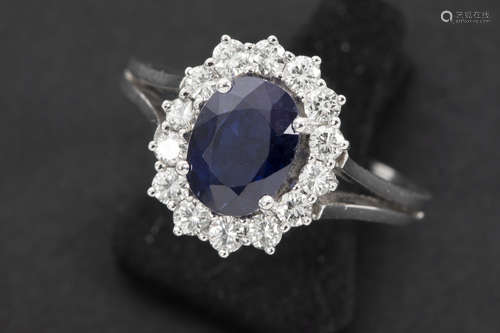 ring in white gold (18 carat) with a ca 2,20 carat oval sapphire surrounded by ca 0,80 carat of high quality brilliant cut diamonds