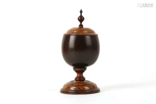 A 19TH CENTURY COCONUT AND FRUITWOOD CUP AND COVER the coconut bowl raised on a ringed socle over