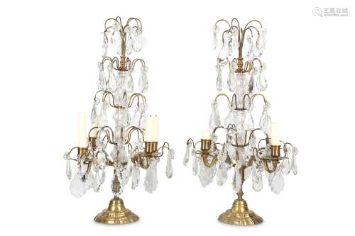 A PAIR OF EARLY 20TH CENTURY BRASS, CUT AND MOULDED GLASS LUSTRE CANDELABRA raised on stepped,