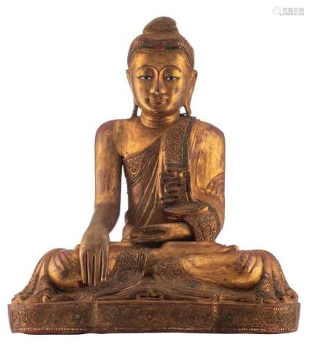 A Thai gilt lacquered wooden seated Buddha with glass
