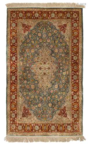 An Oriental silk carpet, decorated with floral motifs