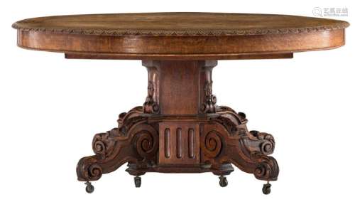 A French oak carved split-pedestal dining table on a