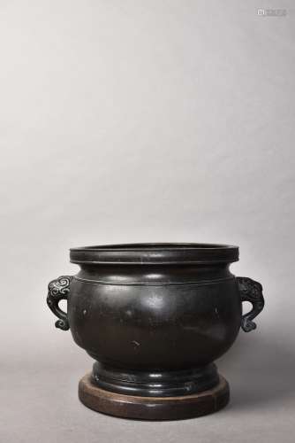 A BRONZE CNESER WITH A WOOD BASE