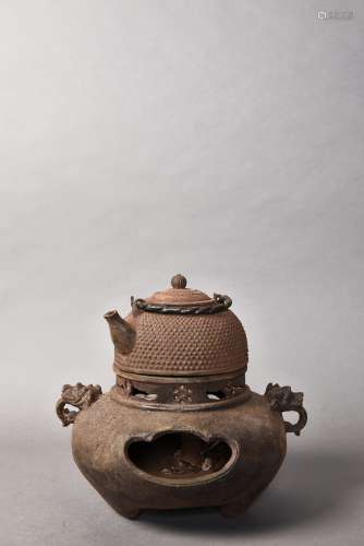 A IRON TEAPOT WITH A STOVE
