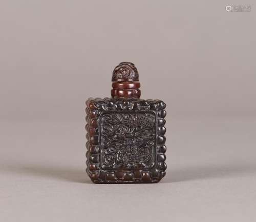 A PEKING GLASS SNUFF BOTTLE WITH DRAGON RELIEF