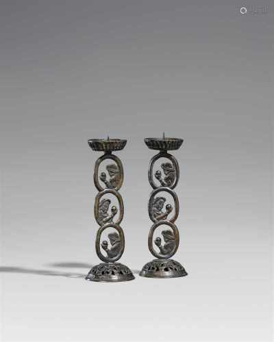 Zwei Kerzenhalter. Bronze. 19. Jh.Über einem im Rankenmuster durchbrochenen Fuß drei Ovale mit