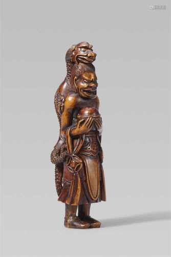 A fine boxwood netsuke of Ryûjin’s attendant. Late 19th centuryStanding upright with a dragon