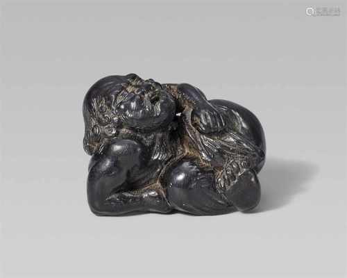 A fine kaki wood netsuke of a muscular kuronbôjin, by Issan. Early 19th centuryReclining and looking