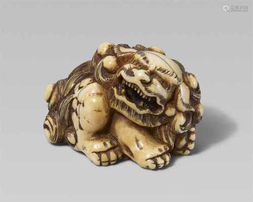 An ivory netsuke of a mighty shishi. Late 18th/early 19th centurySeated, the head turned to the