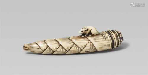 A stag antler netsuke of a rat on a bamboo shoot. 19th centurySitting with a trailing tail on a long